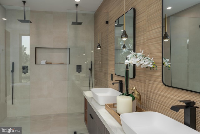 bathroom with vanity, an enclosed shower, and tile walls