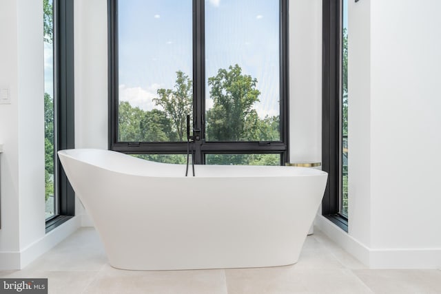 bathroom with tile patterned floors and a tub to relax in