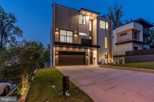 contemporary house with a garage, a balcony, and a front lawn