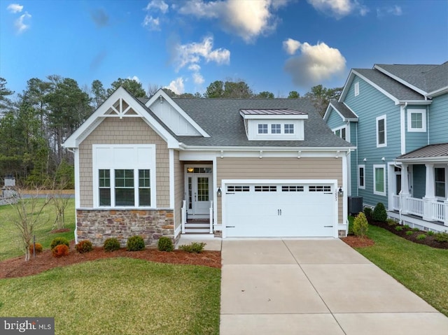 craftsman house featuring cooling unit, a garage, and a front yard