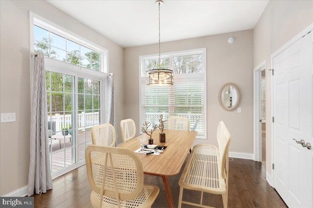 dining room with dark hardwood / wood-style flooring and an inviting chandelier