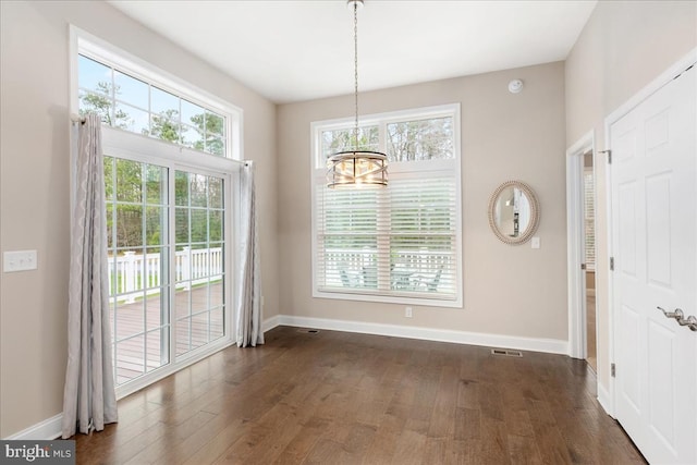 unfurnished dining area featuring dark hardwood / wood-style flooring and a wealth of natural light