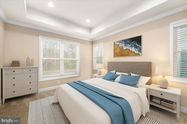 bedroom with a tray ceiling, multiple windows, light carpet, and crown molding