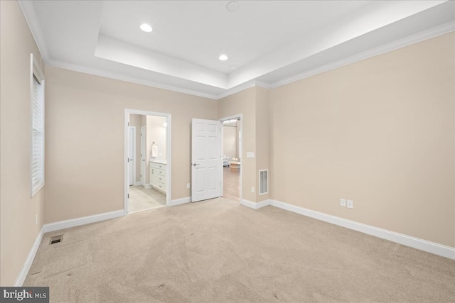 unfurnished bedroom with crown molding, light carpet, and ensuite bath