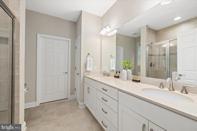 bathroom featuring tile patterned flooring, vanity, and a shower with shower door