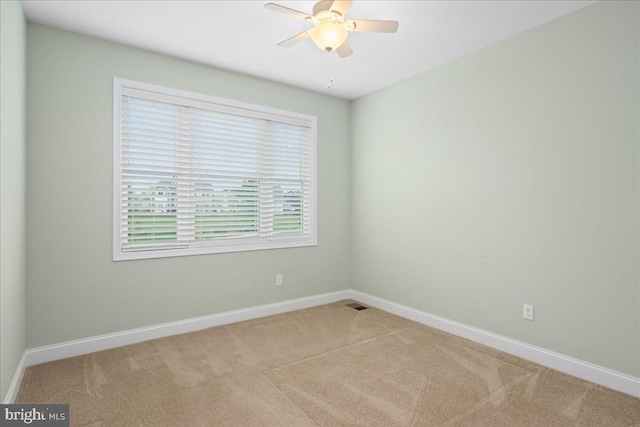 carpeted spare room featuring ceiling fan