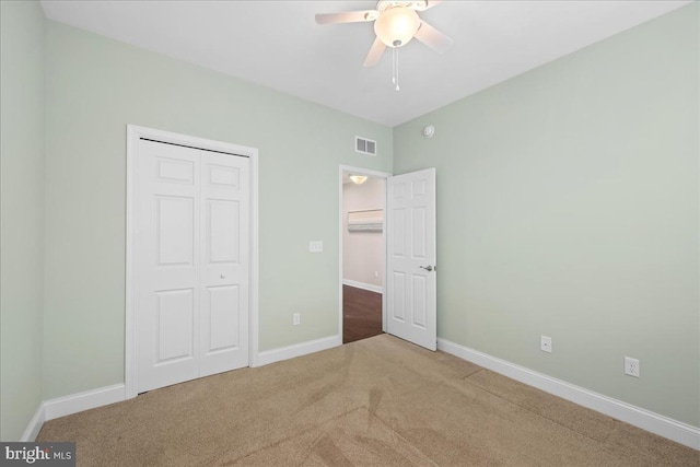 unfurnished bedroom featuring ceiling fan, a closet, and carpet floors