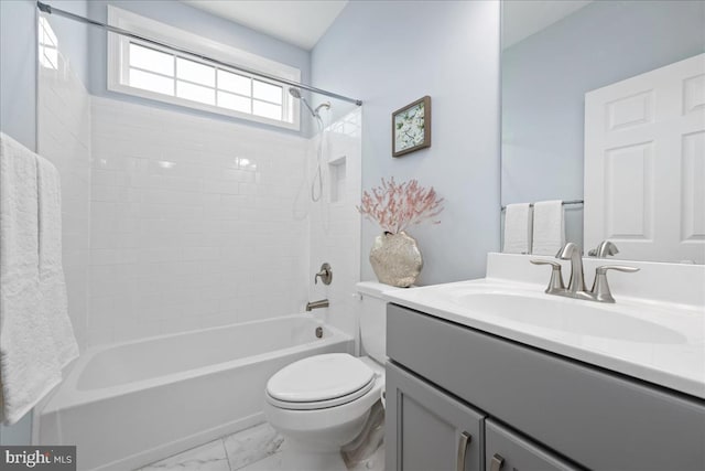 full bathroom with tiled shower / bath, vanity, and toilet