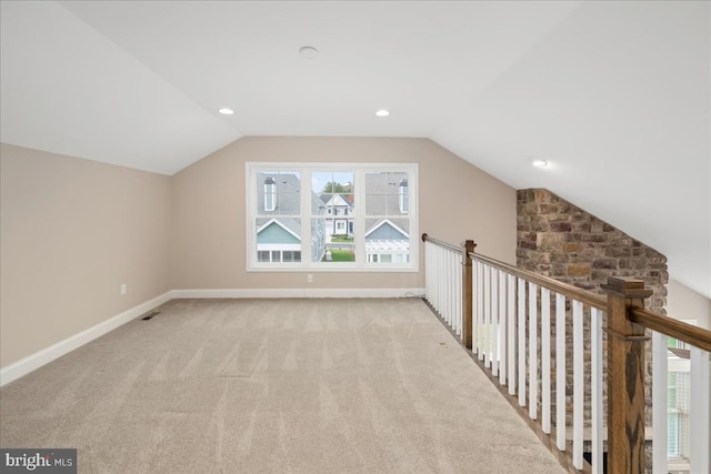 bonus room with light carpet and vaulted ceiling