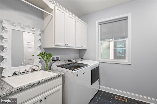 washroom featuring washing machine and clothes dryer, cabinets, and sink