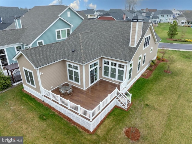 back of house with a deck and a lawn