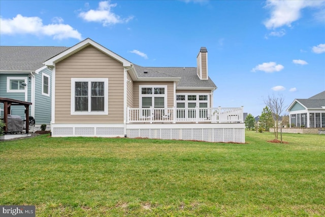 rear view of property with a lawn and a deck