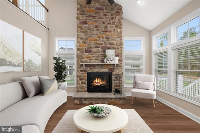 living room with a fireplace, high vaulted ceiling, plenty of natural light, and dark wood-type flooring