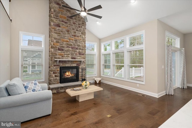 living room with a healthy amount of sunlight, dark hardwood / wood-style flooring, a fireplace, and high vaulted ceiling