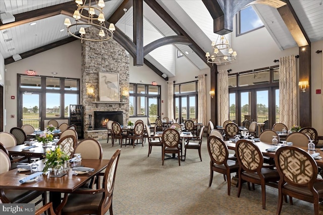 dining space with a fireplace, beam ceiling, carpet floors, and high vaulted ceiling