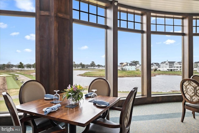 dining area featuring carpet floors and a water view