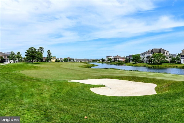 view of home's community featuring a lawn and a water view