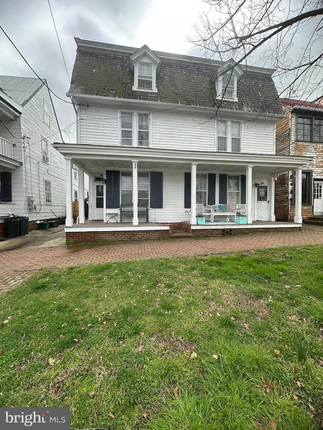 view of front facade featuring covered porch and a front lawn