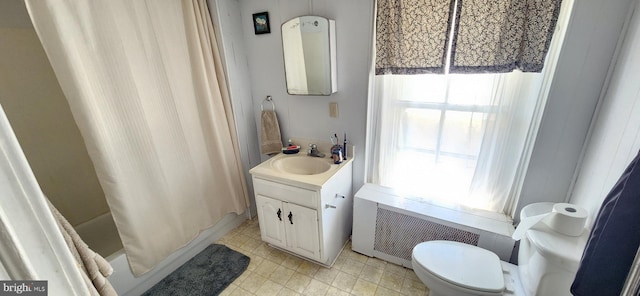 full bathroom with vanity, toilet, radiator, and shower / tub combo with curtain