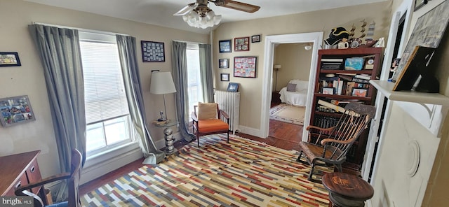 living area featuring ceiling fan, plenty of natural light, and hardwood / wood-style flooring