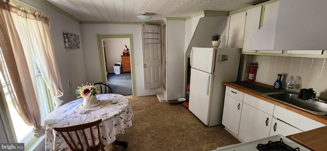 kitchen with sink, tasteful backsplash, white refrigerator, white cabinets, and exhaust hood