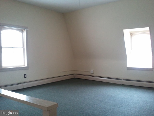 carpeted spare room with a baseboard heating unit