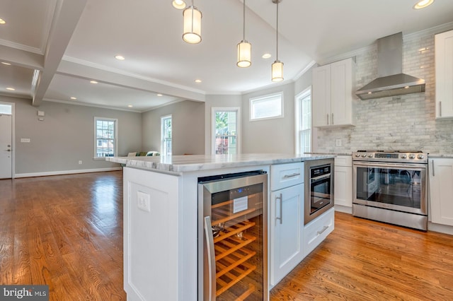 kitchen with stainless steel appliances, wine cooler, white cabinetry, and wall chimney exhaust hood