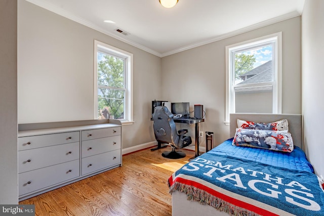 bedroom with light hardwood / wood-style flooring, multiple windows, and ornamental molding