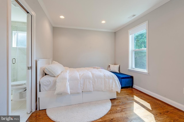 bedroom with ensuite bathroom, hardwood / wood-style flooring, and ornamental molding