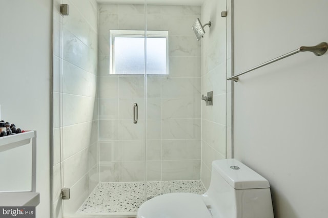 bathroom with toilet and a shower with shower door