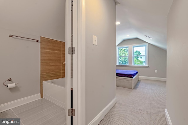 bathroom featuring a bathtub and vaulted ceiling