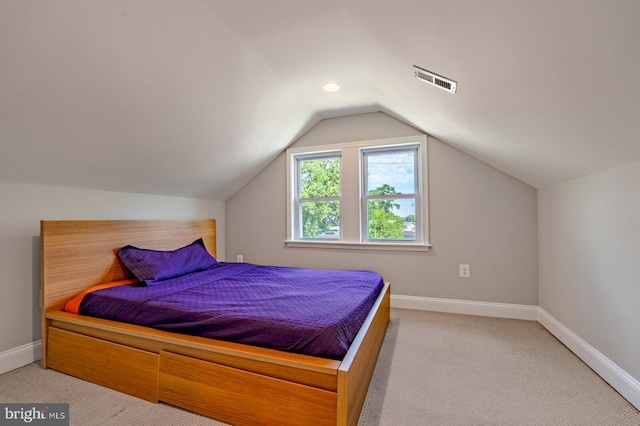 bedroom featuring light carpet and lofted ceiling