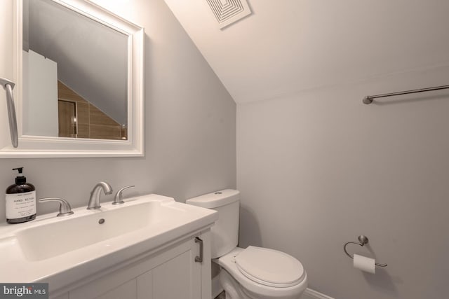 bathroom featuring sink, vaulted ceiling, and toilet