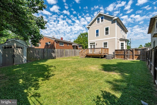 back of house featuring a lawn, central AC unit, a shed, and a wooden deck