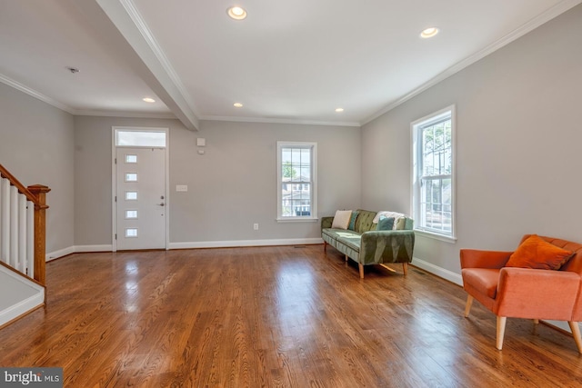 sitting room with beamed ceiling, wood-type flooring, and crown molding