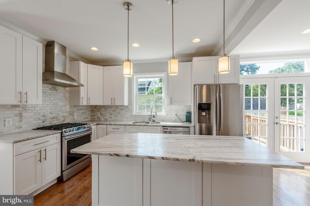 kitchen with wall chimney exhaust hood, white cabinetry, appliances with stainless steel finishes, and french doors