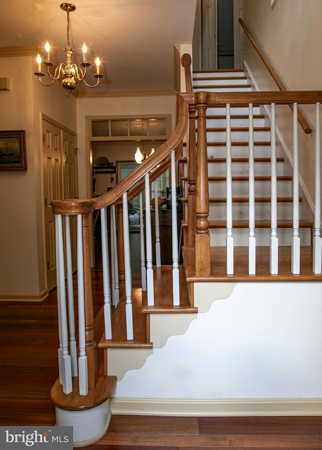 staircase with a notable chandelier, wood-type flooring, and crown molding