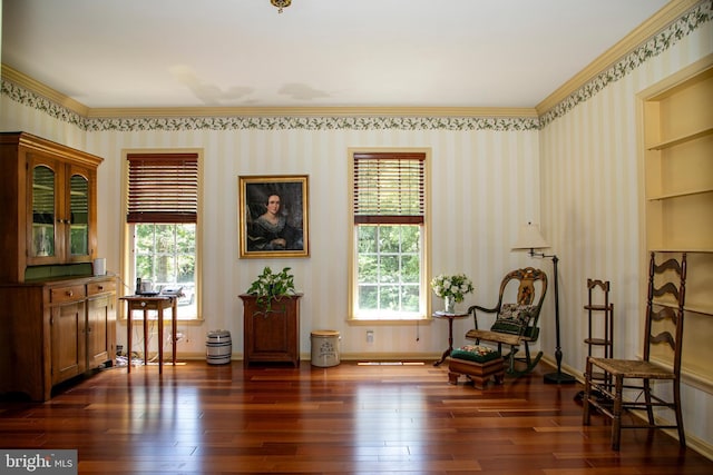 sitting room with built in shelves, dark hardwood / wood-style flooring, and ornamental molding