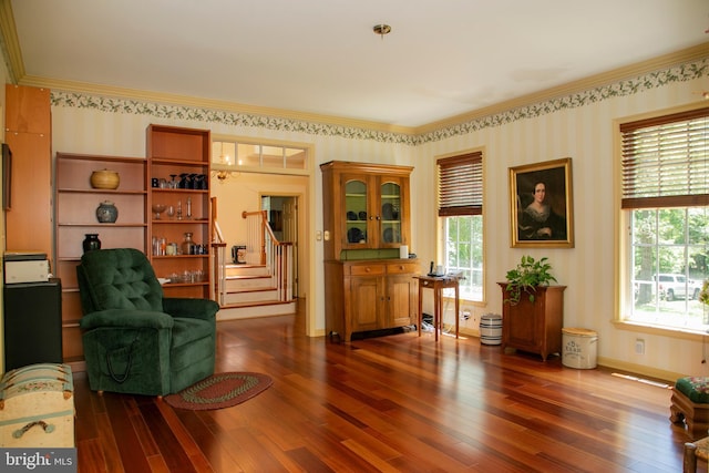 living area with dark hardwood / wood-style floors, plenty of natural light, and crown molding