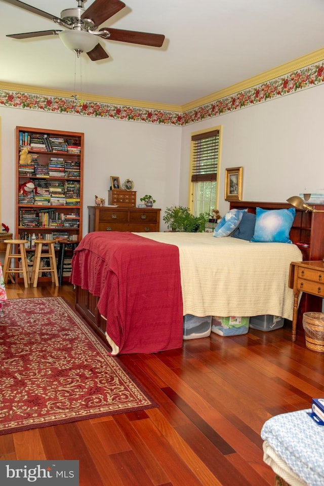 bedroom with hardwood / wood-style floors, ceiling fan, and ornamental molding