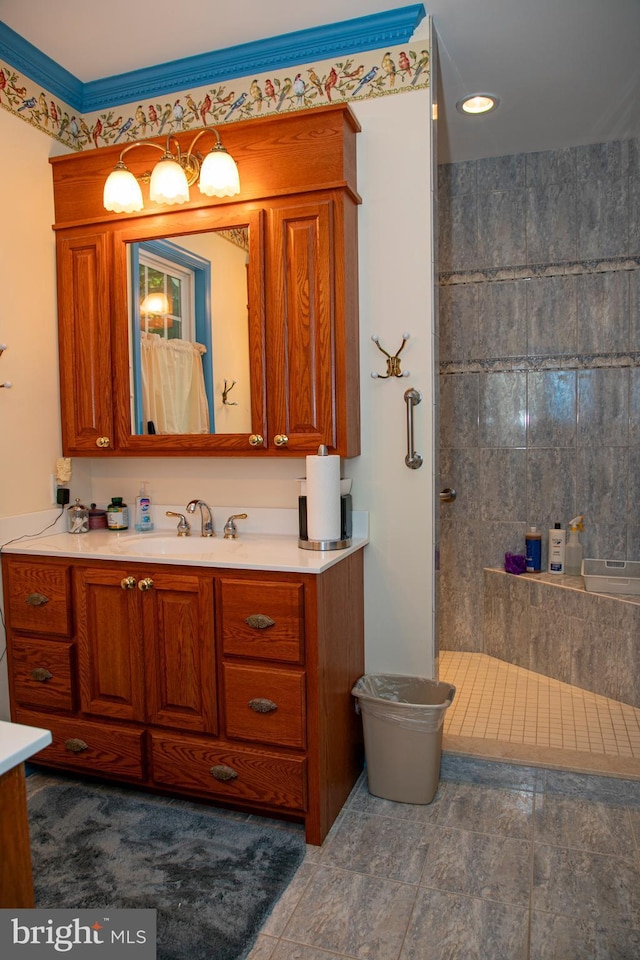 bathroom with a tile shower, tile patterned flooring, and vanity