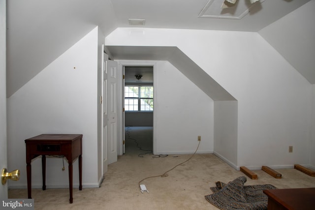 additional living space with light carpet and vaulted ceiling