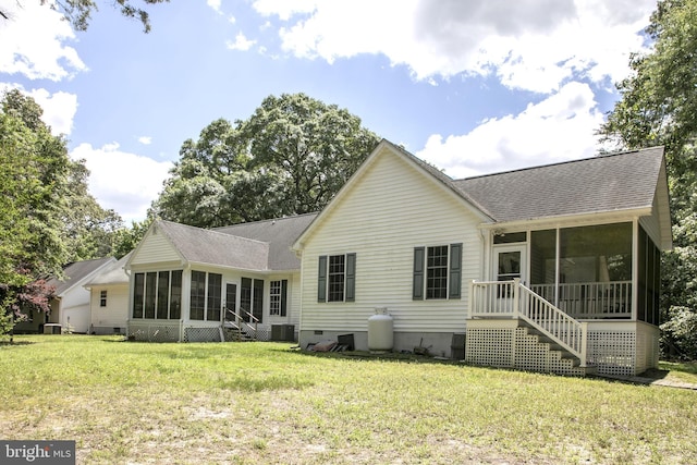 rear view of house featuring a sunroom, a yard, and central air condition unit