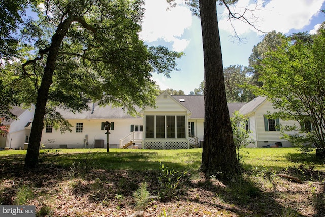 rear view of property with a yard and a sunroom