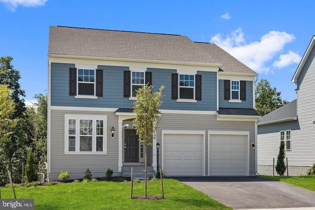 view of front of home with a front yard and a garage