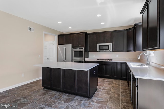 kitchen featuring appliances with stainless steel finishes, a center island, and sink