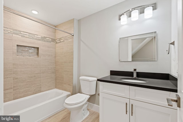 full bathroom with toilet, tiled shower / bath combo, hardwood / wood-style flooring, and vanity