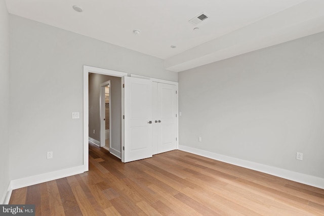 unfurnished bedroom with a closet and hardwood / wood-style flooring