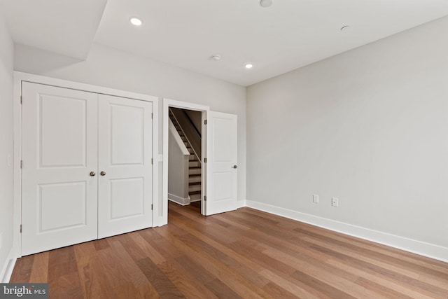 unfurnished bedroom with a closet and wood-type flooring