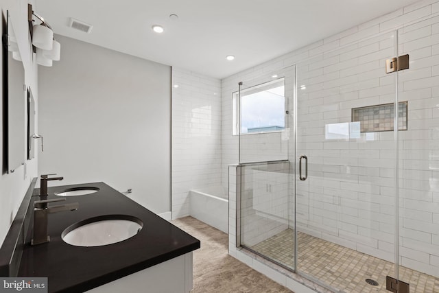 bathroom featuring vanity and independent shower and bath